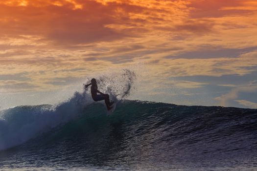 Surfer on Amazing Wave at sunset time, Bali island.