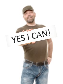 A bearded man with a white board and the message yes i can