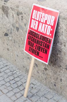 Munich, Germany - February 7, 2015: Protest sign placard of anti-NATO rally demonstration against NATO expansion and increased presence of North Atlantic Alliance in Europe