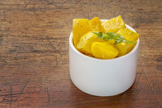 golden beet salad with aragula - small tasting bowl against rustic wood