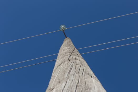 insulators and wire on a wooden pole