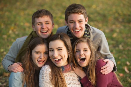 Five laughing white teenage males and females together