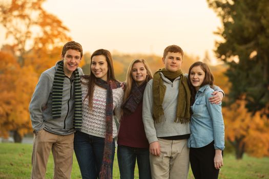 Cute group of teenaged males and females in scarves outdoors