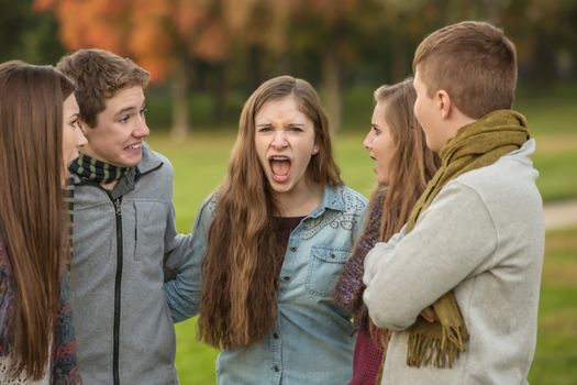 Screaming female teen with group of startled friends