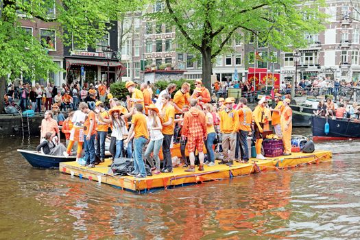 AMSTERDAM - APRIL 26: Canals of Amsterdam full of people in orange on boats during the celebration of kings day on April 26, 2014 in Amsterdam, The Netherlands