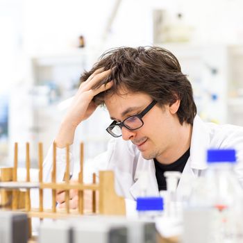 Male researcher carrying out scientific research in a lab (shallow DOF; color toned image)