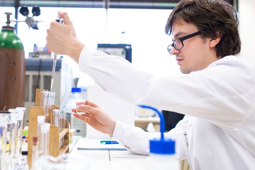 Male researcher carrying out scientific research in a lab (shallow DOF; color toned image)