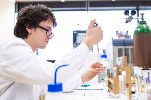 Male researcher carrying out scientific research in a lab (shallow DOF; color toned image)