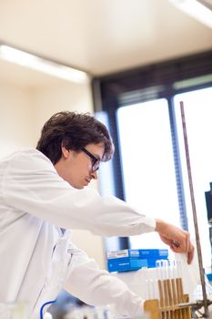 Male researcher carrying out scientific research in a lab (shallow DOF; color toned image)