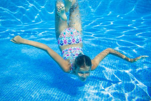 Underwater happy cute girl in swimming pool