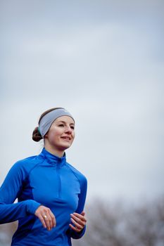 Portrait of a woman running against against blue sky