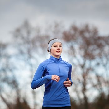 Portrait of a woman running against against blue sky