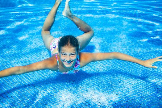 Underwater happy cute girl in swimming pool