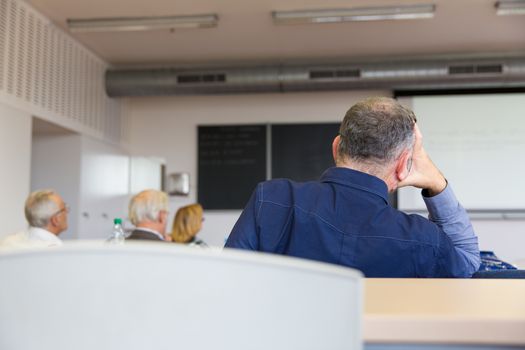 Elderly people are sitting in a classroom, learning something new despite their age