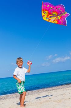 Summer vacation - Cute boy flying kite beach outdoor.