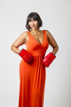 late twenties philipinos woman in low cut orange dress with boxing glove on her hips