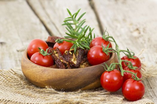 fresh and dried tomatoes on wooden background