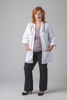 forty something woman doctor with red hair with a stethoscope and a headset
