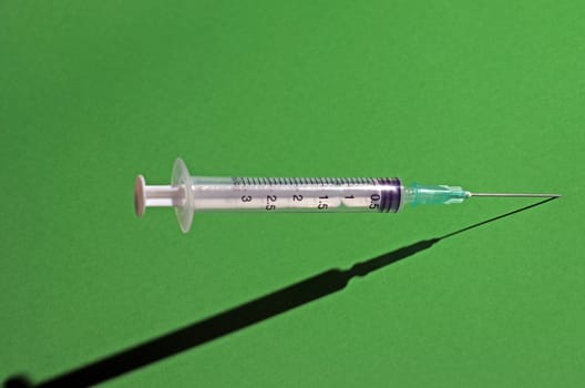 piccture of single medical medical syringe on color backgrouund