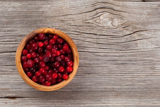 frozen cowberries on wooden background