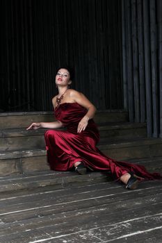 Attractive brunette woman in red sitting on the stairs