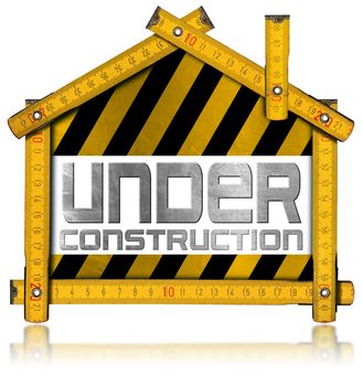 Wooden meter ruler in the shape of house with text under construction. Isolated on white background
