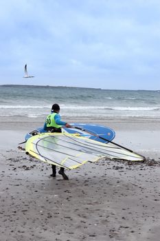 windsurfer getting ready to surf on the beach in the maharees county kerry ireland