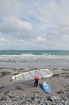 windsurfer getting equipment ready on the beach in the maharees county kerry ireland