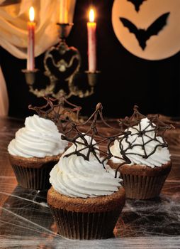 Muffin with whipped cream and chocolate cobwebs for Halloween