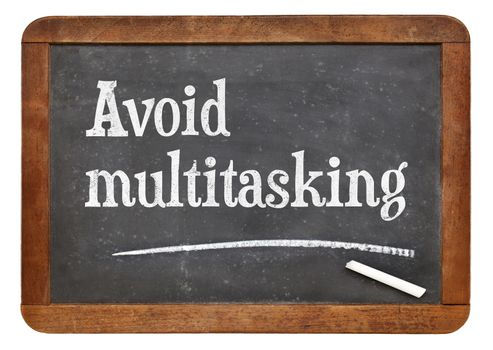 Avoid multitasking advice  on a vintage slate blackboard