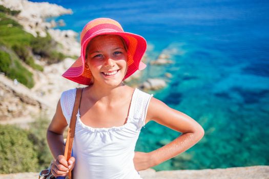 Summer vacation, lovely girl walking on the beach near water