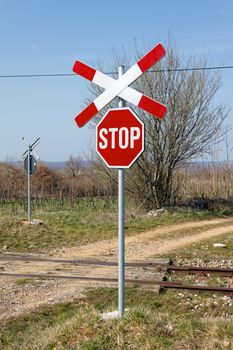 unguarded railway crossing with St. Andrews cross in early spring