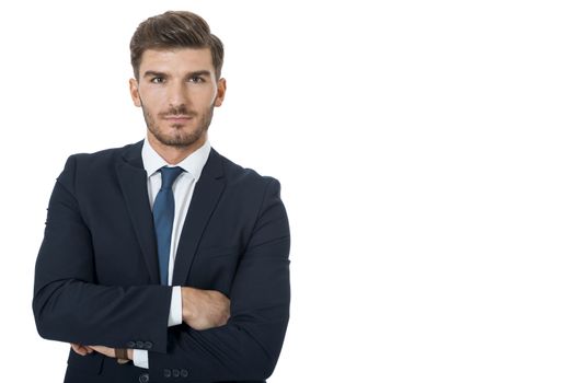 Stylish successful handsome young businessman standing in a relaxed pose with his hands in his pockets and his suit jacket open, isolated on white