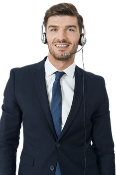 Young bearded handsome man wearing formal business suit and headset with stereo headphones and microphone while smiling at camera, portrait on white