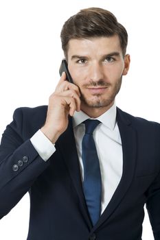 Stylish handsome young businessman chatting on his mobile phone listening to the call with a beaming smile of pleasure, isolated on white