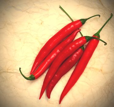 chili pepper on a old paper surface background. instagram image style