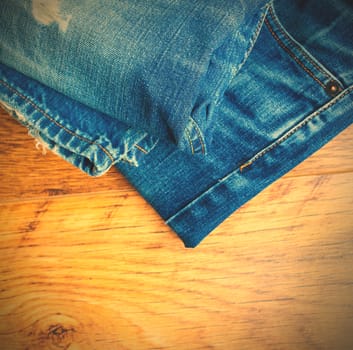 Lot of different blue jeans on the wooden shelf. instagram image style