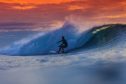 Surfer on Amazing Wave at sunset time, Bali island.