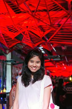 Portrait of young woman on lights ceiling background