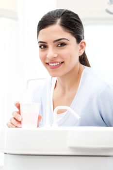 Woman filling the water from sink at dental clinic