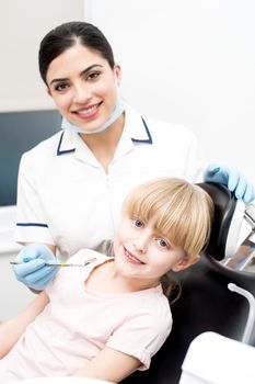 Dental assistant and little girl looking at camera