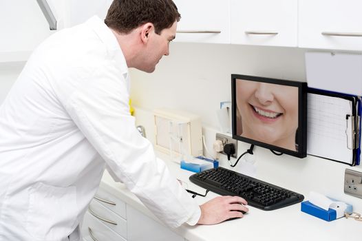 Dentist checking patient teeth in computer screen