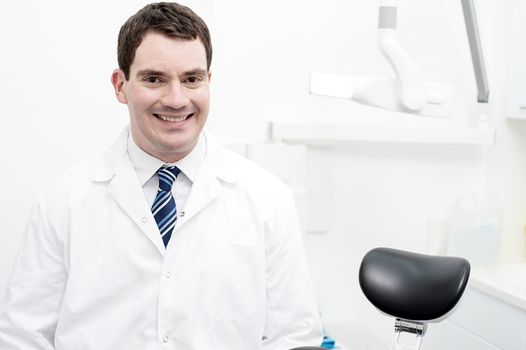 Friendly male dentist smiling at dental clinic