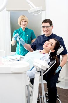 Woman at dental clinic with doctor and his assistant