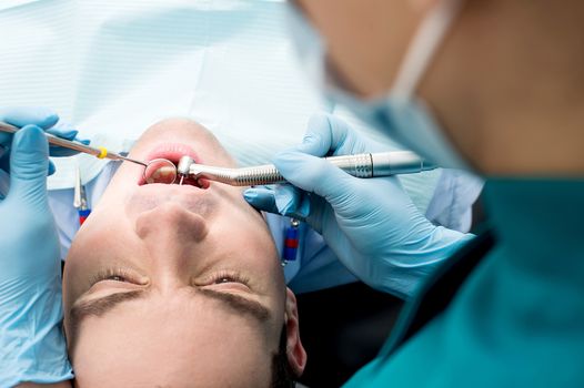 Top view of male patient examining by dentist