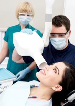 Male dentist takes jaw x-ray of female patient