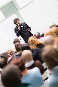 Speaker Giving a Talk at Business Meeting. Audience in the conference hall. Business and Entrepreneurship. Copy space on white board.