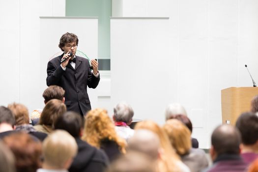 Speaker Giving a Talk at Business Meeting. Audience in the conference hall. Business and Entrepreneurship. Copy space on white board.