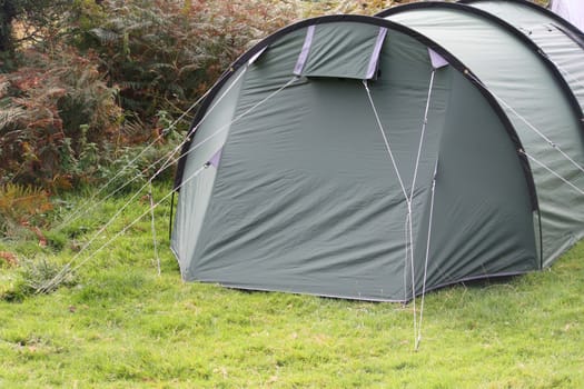 a green tent pitched on grass