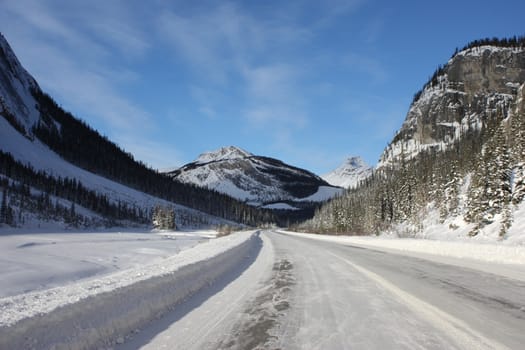 Ice road leading to a mountain under blue sky